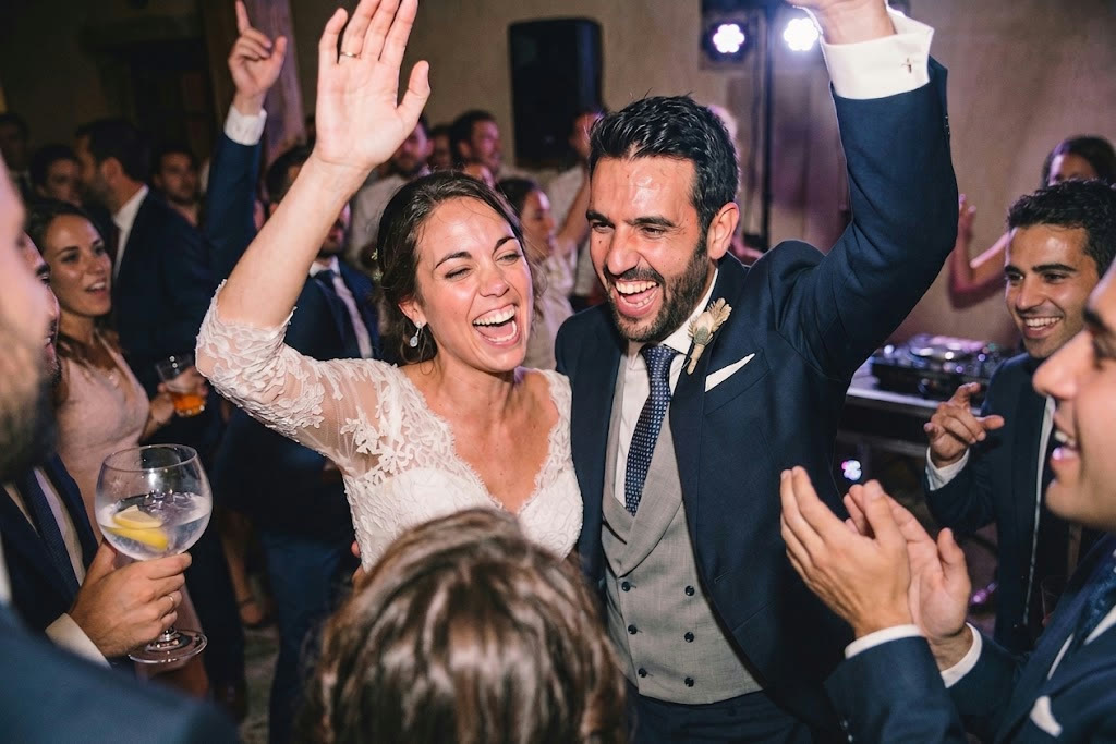 Los novios celebrando en la fiesta rodeados de invitados